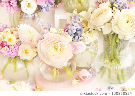 Summer blossoming delicate ranunculus on spring blooming flowers festive background, bright and soft springtime bouquet floral card, selective focus 130858534