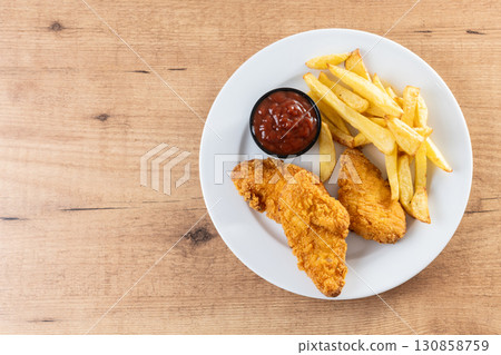 Crispy fried chicken tenders with french fries 130858759