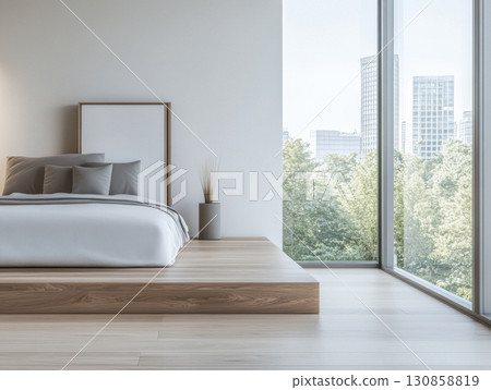 Modern bedroom interior with large windows overlooking greenery in an urban setting 130858819