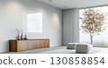 Modern living room with minimalist design featuring natural light and simple furniture in a peaceful setting 130858854