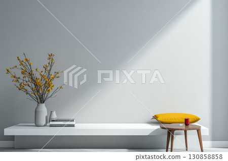 Bright and minimal indoor space with a yellow cushion and a vase of flowers on a white shelf 130858858