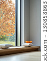 Serene indoor space showcasing minimalist design and nature view with autumn colors in the background 130858863