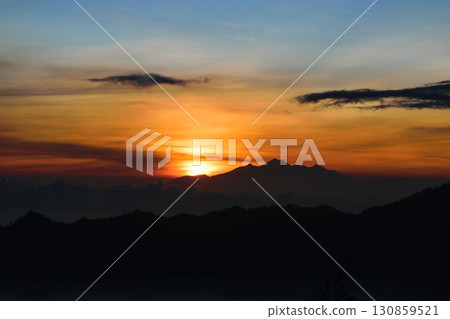Early sunrise view from Gunung Batur volcano in Bali with visible silhouette of Rinjani mountains Early sunrise view from Gunung Batur volcano in Bali with visible silhouette of Rinjani mountains 130859521