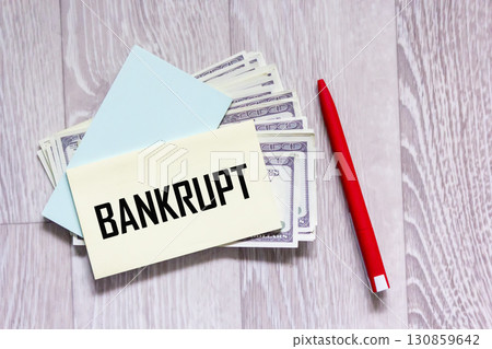 The word "bankrupt" is written on the sticker that lies on the hundred dollar bills. The word "bankrupt" is written on the sticker that lies on the hundred dollar bills. 130859642