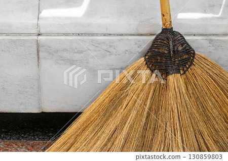 Abstract background of straw broom and white marble wall Abstract background of straw broom and white marble wall 130859803