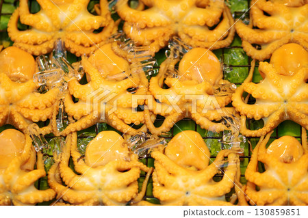 Background of yellow squids on green banana leaf 130859851