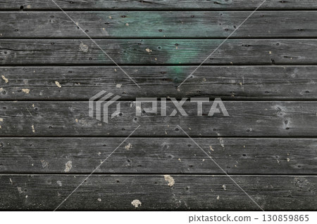 Background surface of old and grey wooden boards wall with visible green area 130859865