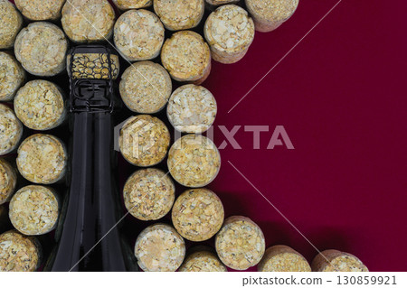 Black champagne bottle surrounded of many champagne corks Black champagne bottle surrounded of many champagne corks 130859921