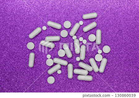 Bunch of different forms white medication pills on shining purple background surface Bunch of different forms white medication pills on shining purple background surface 130860039