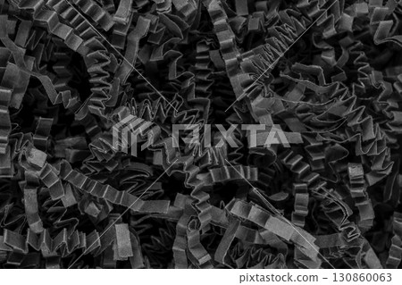 Close up view of bunch shredder black curly carton paper strips background surface 130860063