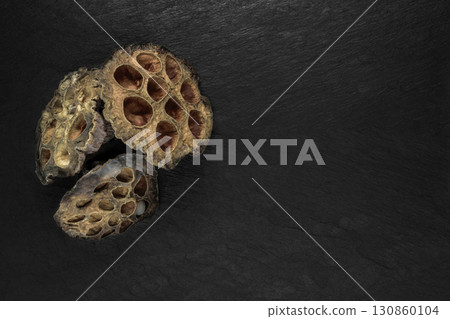 Dry Lotus Flower Blossom on Black Stone Background Surface with Free Space 130860104
