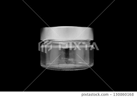 Glass jar with metal lid on it isolated on black background surface 130860168