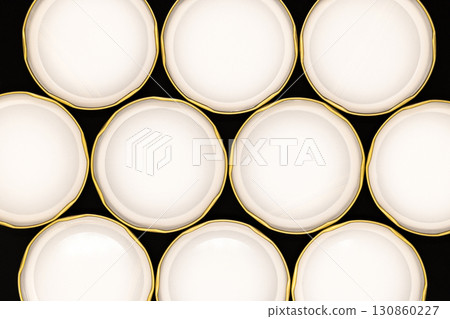 Inner side of golden jar lids on black background 130860227