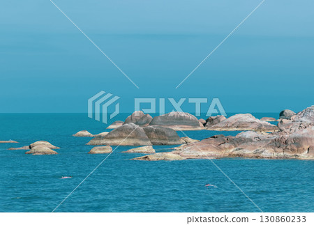 Landscape view of blue ocean and sky with rocks in the water 130860233