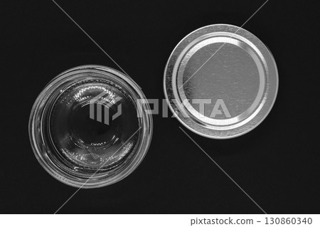 Open glass jar with metal lid on black background surface Open glass jar with metal lid on black background surface 130860340