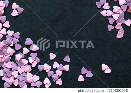 Pink and Purple Sugar Heart Shape Decoration Background on Black Surface With Free Space Pink and Purple Sugar Heart Shape Decoration Background on Black Surface With Free Space 130860358