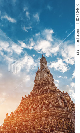 Wat Arun temple in Bangkok at sunset, golden spires of iconic Thai pagoda on Chao Phraya, historic architecture and cultural glow Wat Arun temple in Bangkok at sunset, golden spires of iconic Thai pagoda on Chao Phraya, historic architecture and cultural glow 130860468