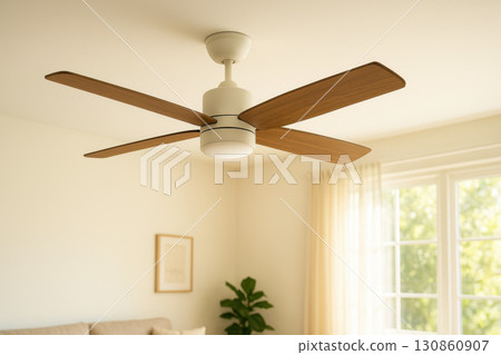 Modern ceiling fan with wooden blades in bright living room elegant home interior design cozy sunlight atmosphere 130860907