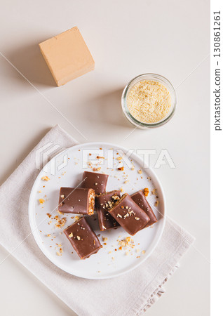 Chocolate nut protein bars on a plate on a table top and vertical view 130861261