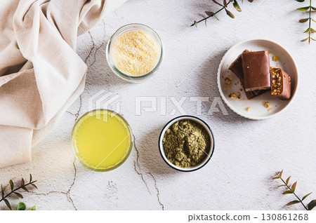 Matcha protein drink in a glass, powder and protein bars on table top view 130861268