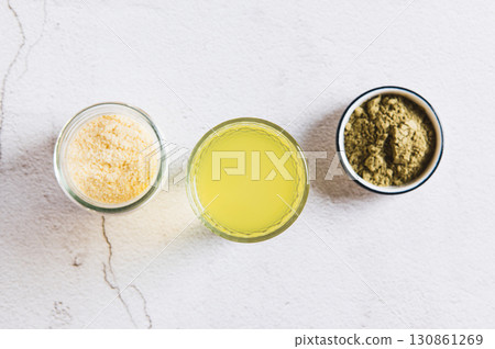 Close up of matcha protein drink in a glass and powders on the table top view Close up of matcha protein drink in a glass and powders on the table top view 130861269
