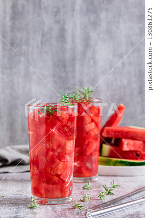 Detox summer drink with watermelon and rosemary in glasses on table vertical view Detox summer drink with watermelon and rosemary in glasses on table vertical view 130861275