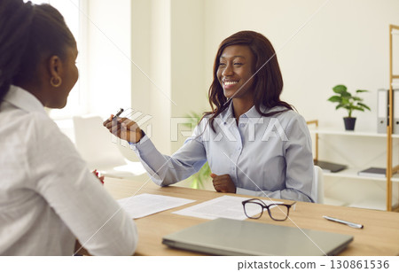 Two African American women meet in the office, make a business deal, and sign a contract 130861536