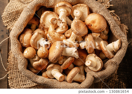 Fresh mushrooms in burlap sack on wooden table with copy space for autumn design concept 130861654