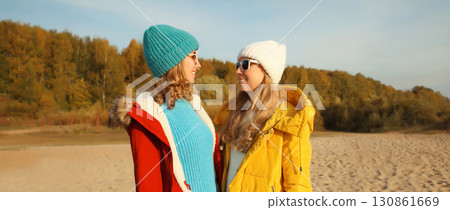 Happy young two women friends on sunny beach, stylish girlfriends smiles together on sea coast 130861669