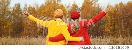 Happy two women friends in autumn park enjoying warm weather, stylish girlfriends together outdoors 130861699