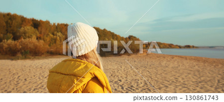 traveler woman looking away on sunny beach, enjoying landscape on sea coast, nature background traveler woman looking away on sunny beach, enjoying landscape on sea coast, nature background 130861743