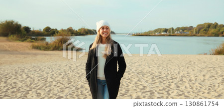 Traveler woman standing on beach, enjoying amazing landscape, looking away, on sea coast background Traveler woman standing on beach, enjoying amazing landscape, looking away, on sea coast background 130861754