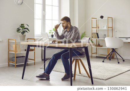 Focused bearded man working at home office with laptop computer 130862941