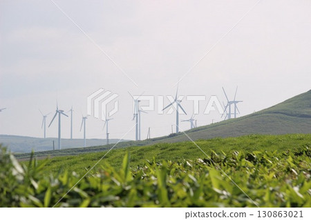 Green hilly landscape lined with wind turbines 130863021