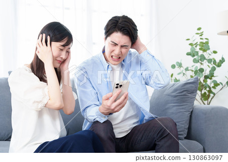 使用智慧型手機的男性和女性感到恐慌和困惑 130863097