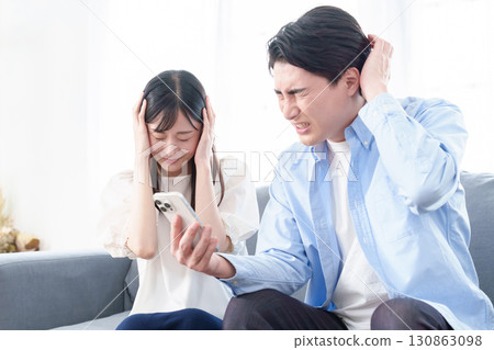 使用智慧型手機的男性和女性感到恐慌和困惑 使用智慧型手機的男性和女性感到恐慌和困惑 130863098