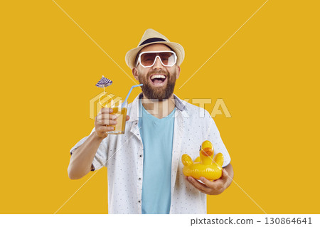 Funny bearded man in beach hat and sunglasses holding cocktail on yellow background. 130864641