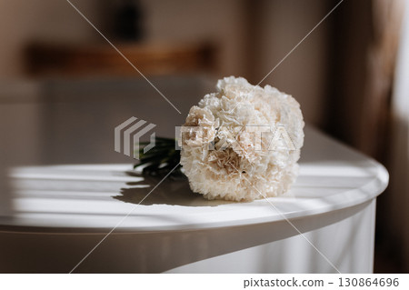 Elegant bridal bouquet on white piano in soft morning light Elegant bridal bouquet on white piano in soft morning light 130864696