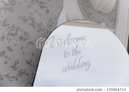 Elegant wedding welcome sign on mirror with soft reflections and calligraphy text 130864714