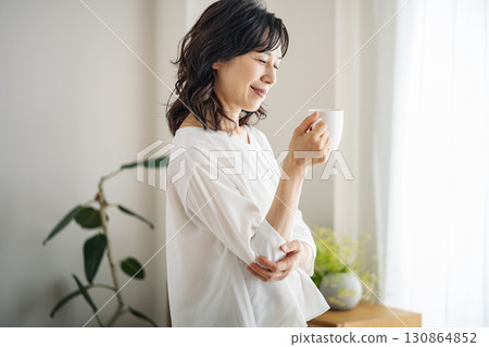 A middle-aged woman in her 50s drinking coffee at home A middle-aged woman in her 50s drinking coffee at home 130864852