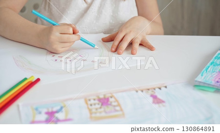 Close-up of a child's hands coloring a drawing with bright pencils. Young girl engaging in colorful artistic drawing and coloring activity using pencils. Enhancing creativity. Imagination Close-up of a child's hands coloring a drawing with bright pencils. Young girl engaging in colorful artistic drawing and coloring activity using pencils. Enhancing creativity. Imagination 130864891