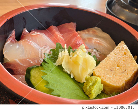 Bowl of rice topped with sashimi  130865013