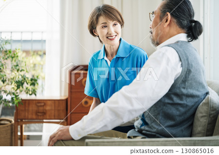 Home helper talking to senior man 130865016