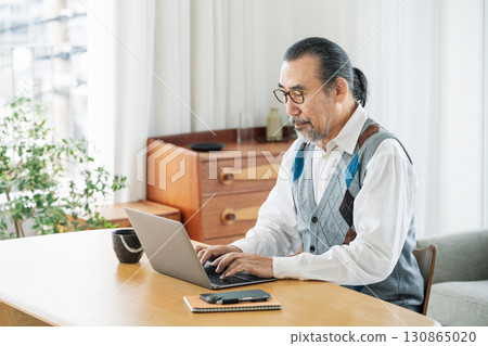 一位老人在家客廳用電腦工作 130865020