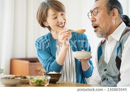 A middle-aged woman feeding her husband 130865045