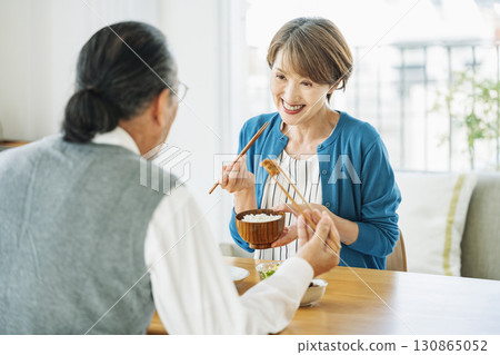 一位中年婦女在家吃晚餐時與丈夫愉快地交談 一位中年婦女在家吃晚餐時與丈夫愉快地交談 130865052