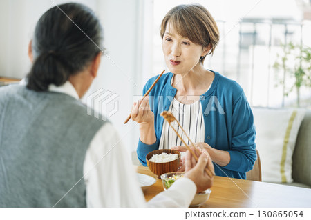一位中年婦女和丈夫在家吃晚餐 一位中年婦女和丈夫在家吃晚餐 130865054