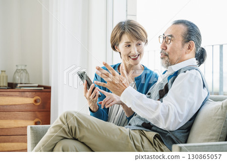 Senior couple talking on the sofa at home 130865057