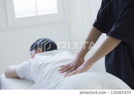 Man receiving chiropractic treatment 130865870