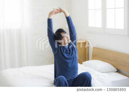 躺在床上伸展的男人 130865893